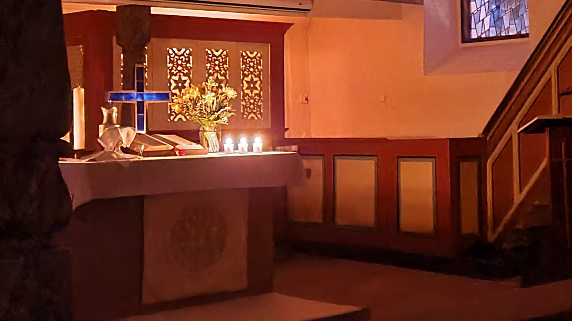 sisäkuva kirkon alttarista pääsiäisaamun hämärässä kynttilänvalossa