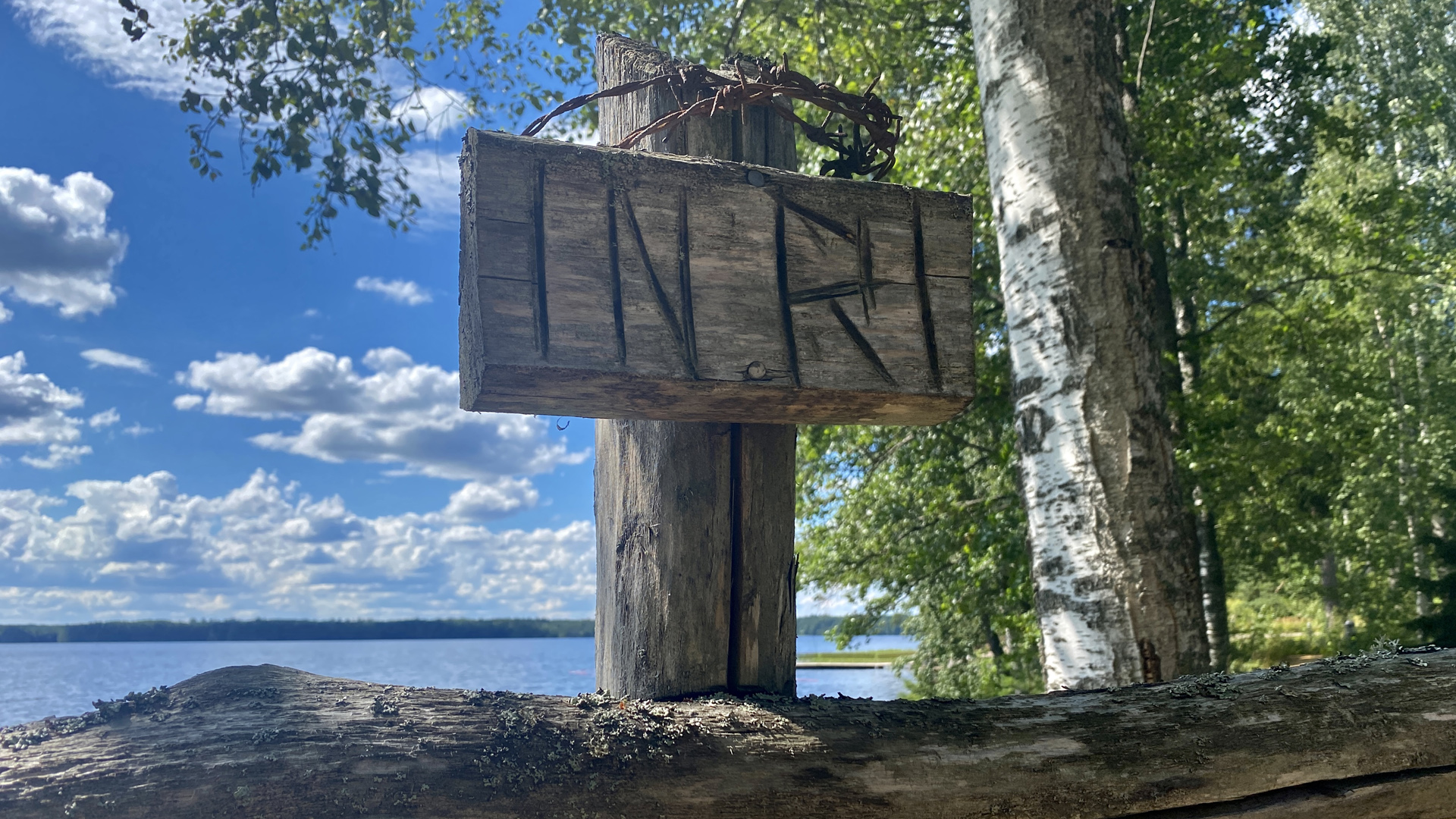 risti järven rannalla, ristissä teksti INRI
