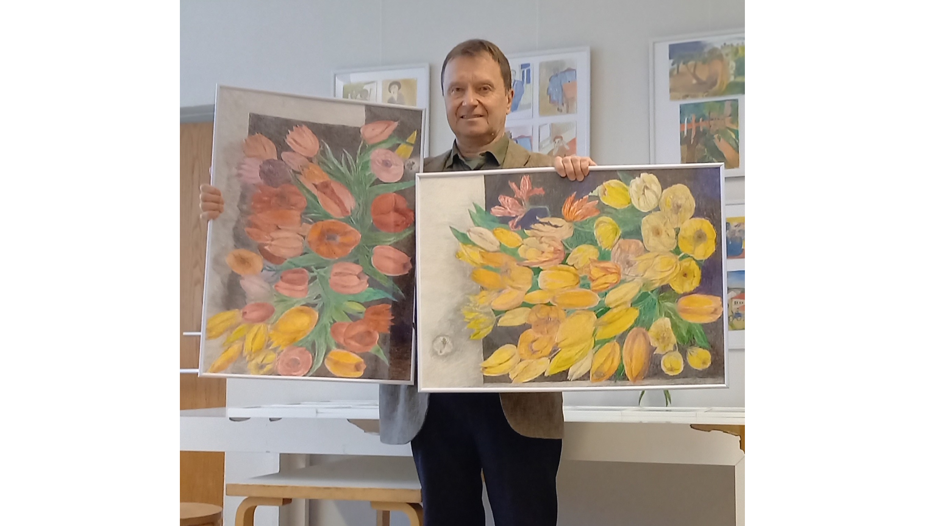 Mikael Merenmies käsissään kaksi kukkataulua