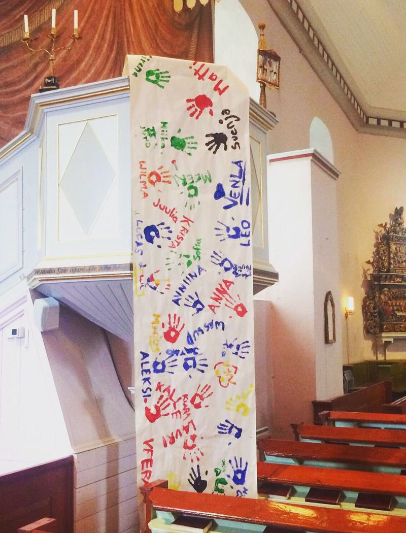 Kirkon saarnatuolista riippuu lakana, jossa on nuorten nimiä ja kädenjälkiä.