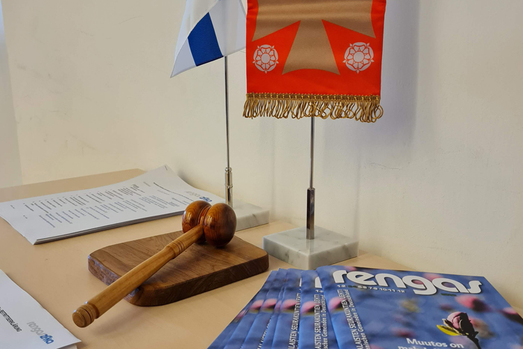 puheenjohtajan nuija, liput ja Rengas-lehtiä pöydällä
